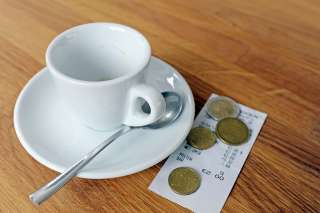 © photophonie - stock.adobe.com Foto: Kaffeetasse mit Rechnung und Münzen